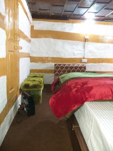 HarsilMountain Village Stay - Dharali Heights Harsil的一间设有两张床和两张搁脚凳的房间