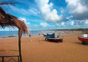 拉帕洛马Complejo Costa Serena-Casas del Mar的沙滩上,沙滩上坐着两艘船