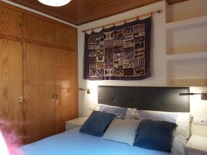 阿林萨尔Ski Station Apartments的卧室配有一张床,墙上挂有绘画作品