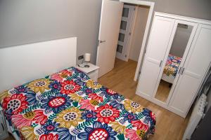 雷乌斯Apartamento Reus 2 - Parking gratuito的一间卧室配有一张带彩色床罩的床