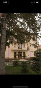 切尔诺夫策Готель Баронський Двір的前面有一棵树的大白色房子