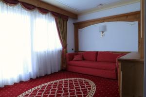 费德拉帕加内拉Hotel Belvedere Srl的客厅设有红色的沙发和窗户。
