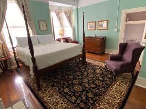 萨凡纳Foley House Inn的一间卧室配有一张床和一把椅子