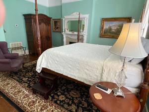 萨凡纳Foley House Inn的一间卧室配有一张床和一张带台灯的桌子