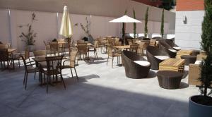 马德里阿尔卡拉套房生态酒店的一间带桌椅和遮阳伞的餐厅