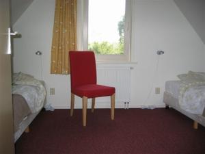 登堡Koperwiek Texel的红色椅子坐在窗户的房间