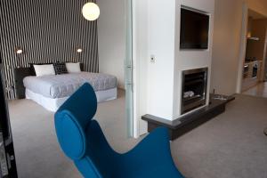 纳皮尔Vue Apartments的一张位于带一张床和壁炉的客房内的蓝色椅子