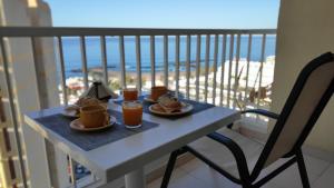 美洲海滩Apartamento Playa las Americas的阳台上的桌子上摆放着食物和饮料