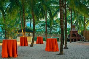 阿布贾Abuja Continental Hotel的两张桌子,上面有蜡烛,在棕榈树海滩上