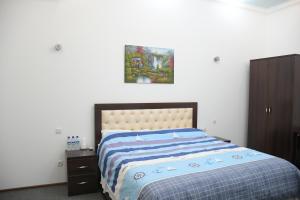 塔什干Nurziyo Guest House的卧室配有一张床,墙上挂有绘画作品
