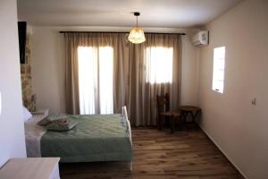 SívasVafis Apartment at Sivas Village的客房设有床、桌子和窗户。