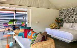 乌鲁瓦图Origin Uluwatu的客房设有两张床、一张沙发和一张桌子。