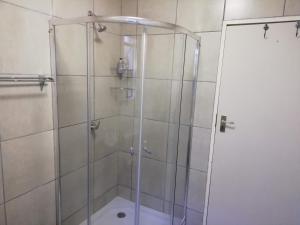 比勒陀利亚Home @ Harry's的浴室里设有玻璃门淋浴