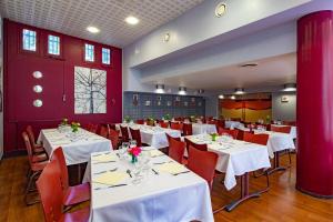 巴黎巴黎凯勒曼CIS酒店的用餐室设有白色桌子和红色墙壁