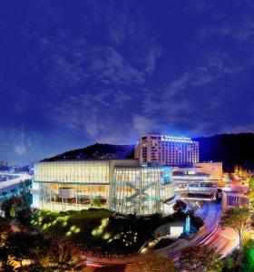 首尔Swiss Grand Hotel Seoul & Grand Suite的享有大型建筑的夜间景色