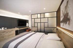 特伦钦特伦钦马格努斯酒店的一间卧室配有一张大床和电视