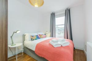 伦敦WelcomeStay Clapham Junction 2 Bedroom Apartment的一间卧室配有带毛巾的床