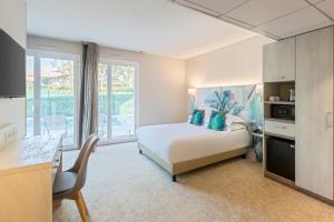 耶尔蓝色海岸耶尔贝斯特韦斯特优质酒店的一间带一张床和一张书桌的卧室和一间厨房