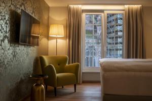 弗莱堡拉蓬蒙斯特广场酒店的卧室配有床、椅子和窗户。