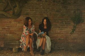 米拉黎莱斯阿尔科瓦德多吉酒店的两个女人坐在砖墙边看书