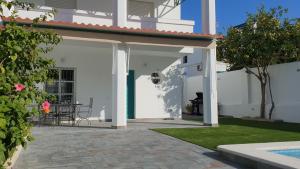 桑卢卡尔-德巴拉梅达Casa Velero 32的白色的房子,设有配有桌子的庭院