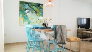 桑卢卡尔-德巴拉梅达Casa Velero 32的一间带桌子和两把蓝色椅子的用餐室