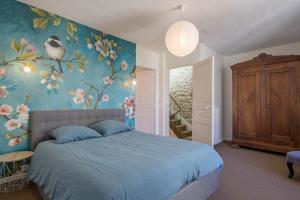 路易港Gîte La Vedette By KEROUZEC sea side and historical center的卧室配有一张蓝色的床,墙上挂着鲜花
