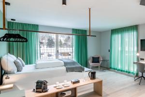 蒂罗尔-泽费尔德Lifestylehotel dasMAX的一间卧室配有一张带绿色窗帘的大床