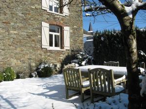 比埃夫勒Bordo Village的大楼旁边的雪地里摆放着桌椅