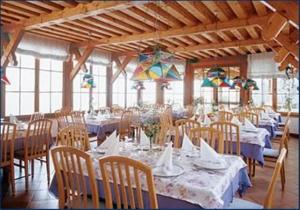 加尔达湖滨阿尔伯格德瓦酒店 的一间设有白色桌椅和窗户的用餐室