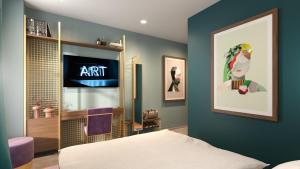 日内瓦Marmont Hotel的一间卧室配有一张床,墙上配有电视