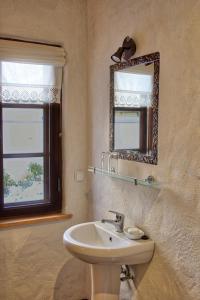 哈普萨卢贝古塔旅馆的一间带水槽和镜子的浴室以及窗户。