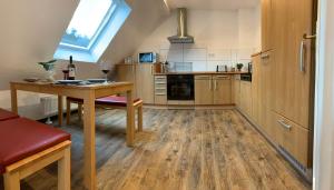 萨尔布吕肯DIE Mansarde !的铺有木地板的厨房、桌子和窗户