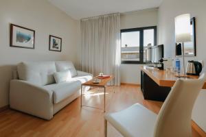 巴塞罗那Hesperia Barcelona Del Mar的客厅配有白色的沙发和桌子