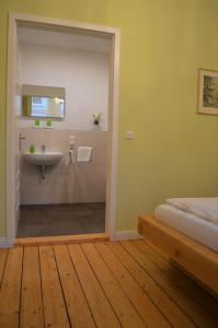 哈默尔恩Altstadtpension Hameln的一间带水槽的浴室和一张位于客房内的床