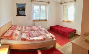 斯祖贝莱克Chalupa Zeleznik的一间带两张床的卧室和红色地毯