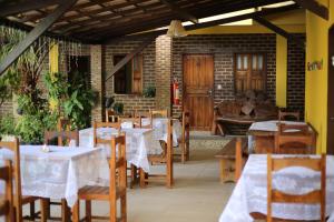 阿拉亚尔达茹达Pousada Aruanã的餐厅设有桌椅和沙发。