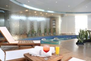 布卡拉曼加布卡拉曼加度假酒店的一个带桌子的游泳池,备有两杯橙汁