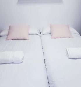 休达Millan Astray的两张单人床、白色床单和枕头