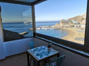 莫甘903 Ocean view house La Cascada的享有海滩景致的客房内的桌椅