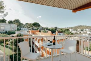 马略卡岛帕尔马Hesperia Ciudad de Mallorca的阳台配有白色椅子和一张桌子及一瓶葡萄酒
