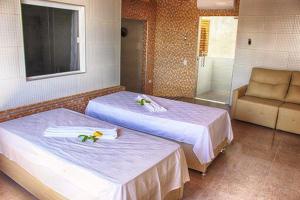 科鲁里皮FLAT RIOMAR的客房设有两张床、毛巾和浴缸。