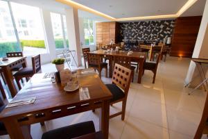 乔卢拉Hotel Posada Señorial的餐厅设有木桌、椅子和窗户。