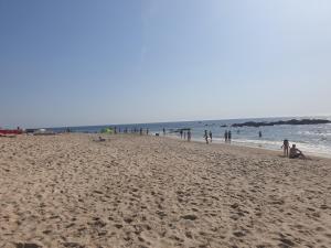 孔迪镇Carminho beach house的一群人,在海边的海滩上