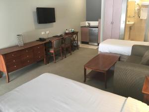 布里斯班香格里拉花园汽车旅馆的一间酒店客房,设有两张床和电视