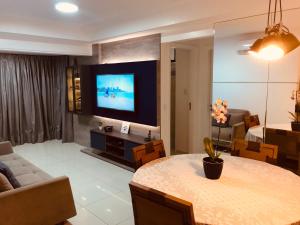 马塞约Apartamento Beira Mar Maceió的客厅配有桌子和电视。