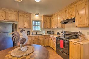布赖森城Newly Built Smoky Mountain Cabin Near Bryson City!的厨房配有木制橱柜和带鸡雕的桌子。