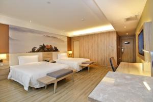 西安西安大寨路亚朵酒店的酒店客房设有两张床和一张桌子。