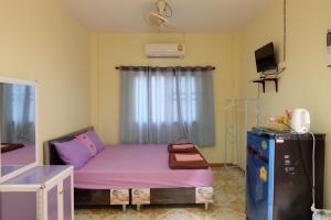 席昌岛Thippawan Bungalow的小客房配有紫色的床和冰箱。