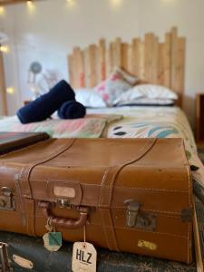 塔卡卡Alpacas Off Grid - Eco Cabin的睡在床上的棕色手提箱